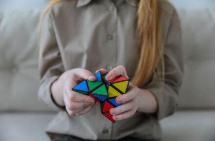 Henkilö pitää käsissään Rubikin kuutiota