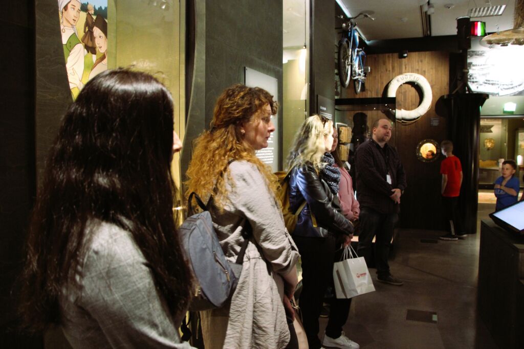 Usea henkilö seisoo katsomassa museonäyttelyä.