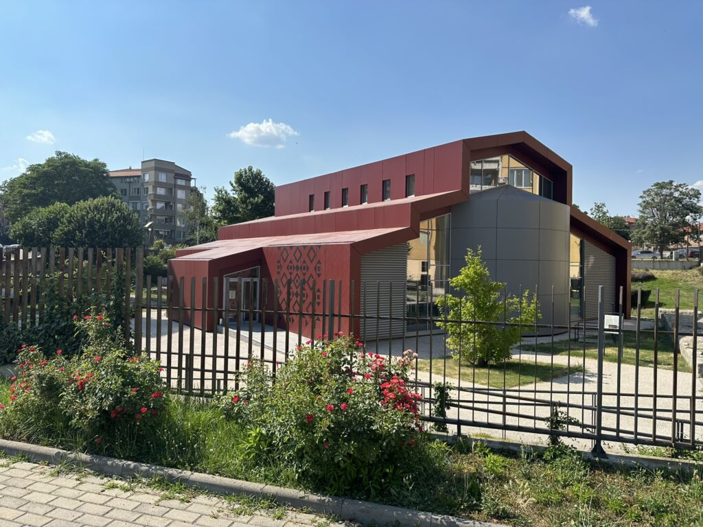 A building with a fence and flowers